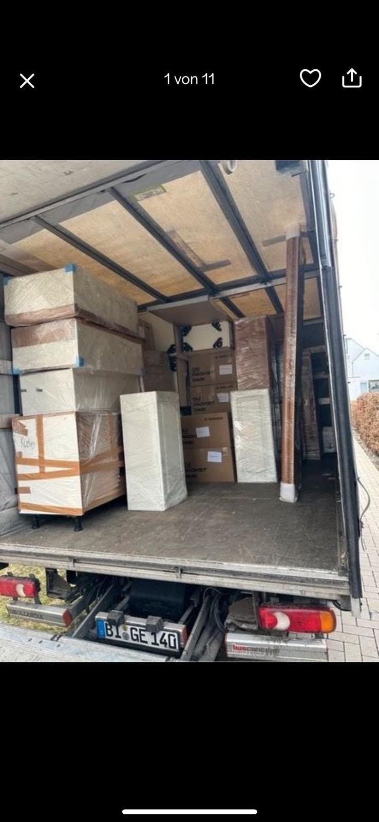 Geöffneter Laderaum mit verpackten Möbeln und Kartons.